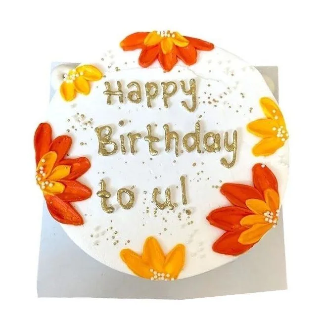 Üzerinde el yazısıyla 'Happy Birthday to u!' yazan çiçekli yazılı pasta